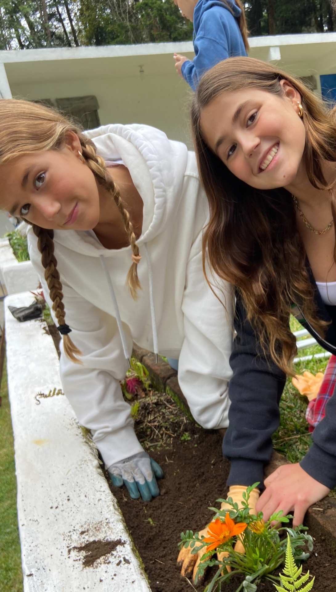 Ana Wolfington and Isabella Wolfington planting flowers